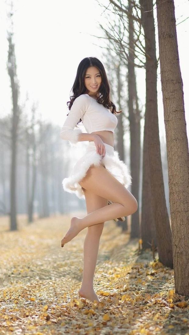 Beautiful Oriental Dressed In White Lifting Her Skirt