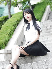 Pretty Asian In A Black Skirt & White Top Sitting On The Steps